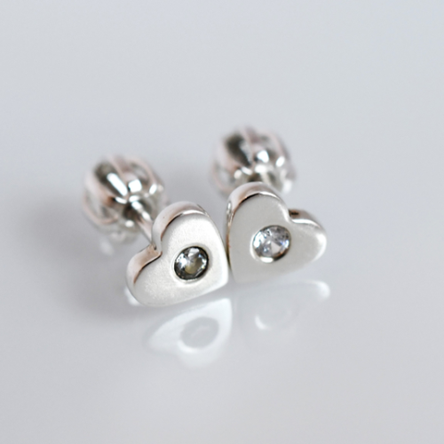 Strieborné náušnice v tvare srdiečok so zirkónmi.